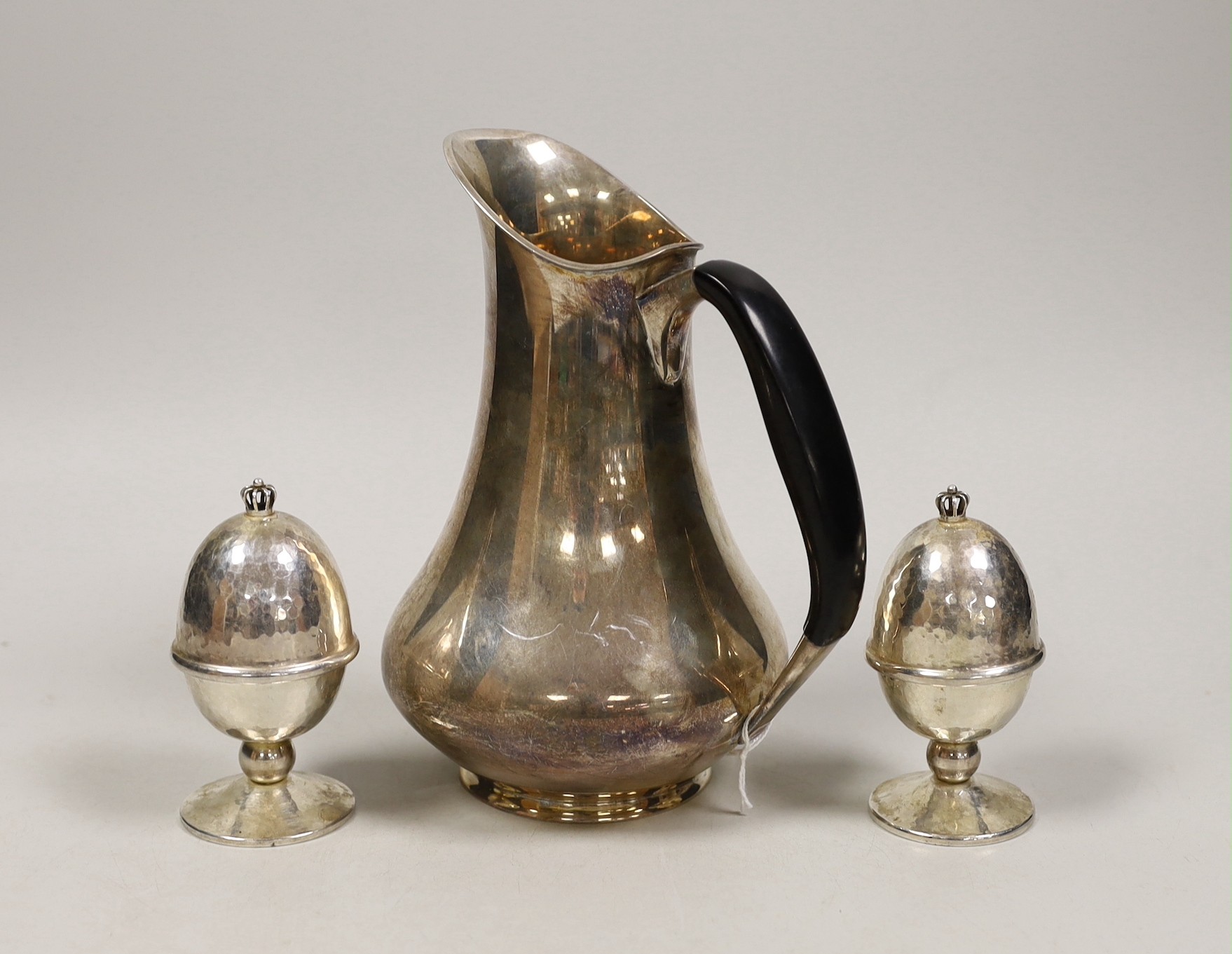 A Danish 830S white metal hot water jug, by Cohr, height 18.9cm and a pair of Danish sterling white metal egg cups and covers by Holmsted, gross weight 16.5oz.